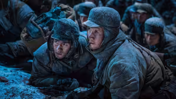 Wu Qianli and Wu Wanli crouch with fellow soldiers in a snow-covered battlefield