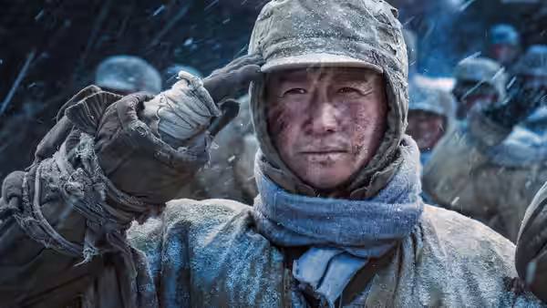 Wu Qianli salutes amid falling snow, bundled in frost-covered winter gear
