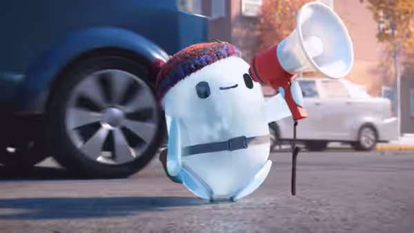 Ron carries a megaphone along a street beside parked cars