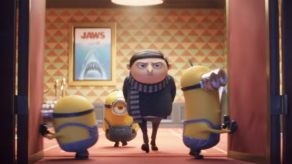 Gru (Steve Carell) walks between Minions (Pierre Coffin) in a Jaws-decorated theater hallway