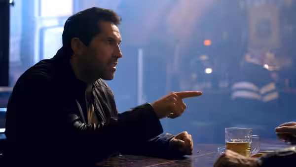 Mike Fallon (Scott Adkins) points across a table in a smoky bar