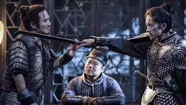 An armored man points a sword at another while a seated man watches