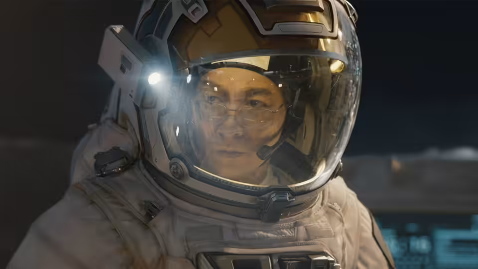 Liu Peiqiang (Wu Jing) in a spacesuit, looking ahead through his helmet visor