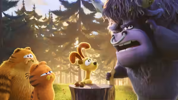 Garfield and a smaller orange cat face Odie and a large purple gorilla in a forest