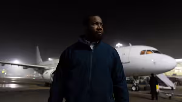 Robert Jackson (Michael Jai White) stands beside a passenger jet on a nighttime tarmac