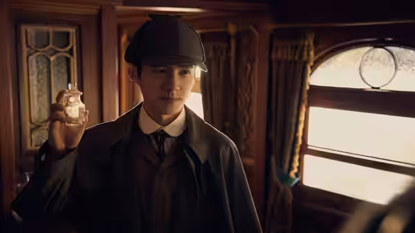 Qin Fu (Liu Haoran) examines a small object inside a train carriage