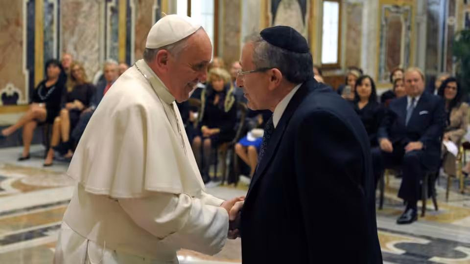 Marvin Hier greets Pope Francis inside a grand hall as guests watch