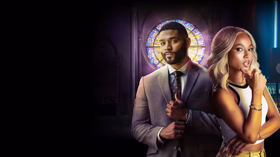 A suited man and blonde woman pose before a stained-glass church window