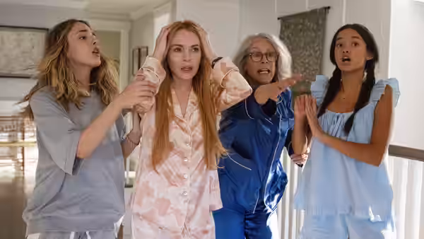Red-haired woman in pajamas clutches her head while older woman points in a home