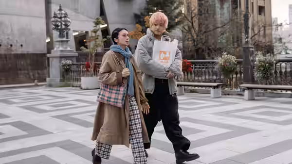 Yui Katakura (Kō Shibasaki) and Sena (Eiji Akaso) walk through a plaza as he carries a paper bag