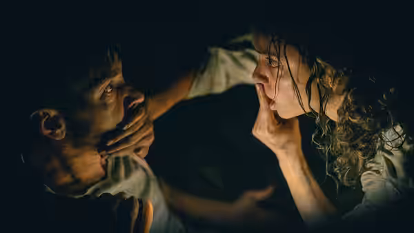 Tess (Georgina Campbell) and a man face each other closely in darkness
