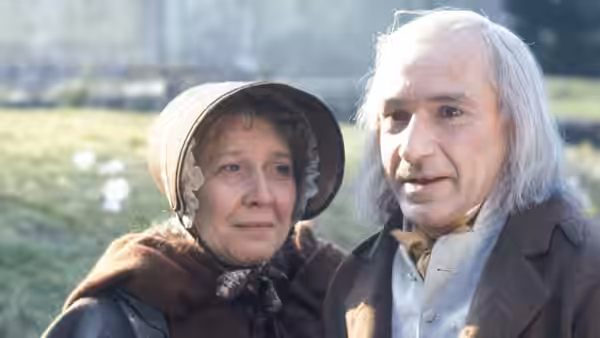 Silas Marner (Ben Kingsley) stands beside Dolly Winthrop (Rosemary Martin) in a sunlit field