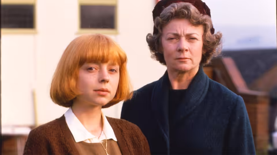 Small Jess (Emily Aston) stands beside Mother (Geraldine McEwan) outside a building