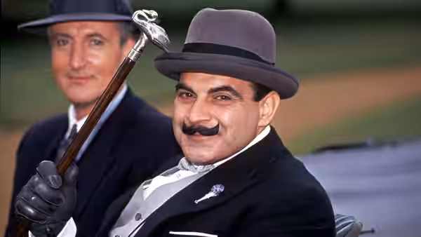 Hercule Poirot (David Suchet) holds his cane beside Captain Hastings (Hugh Fraser) outdoors