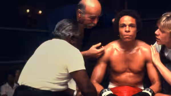 Leon Johnson (Leon Isaac Kennedy) sits in the boxing ring corner as trainers tend to him