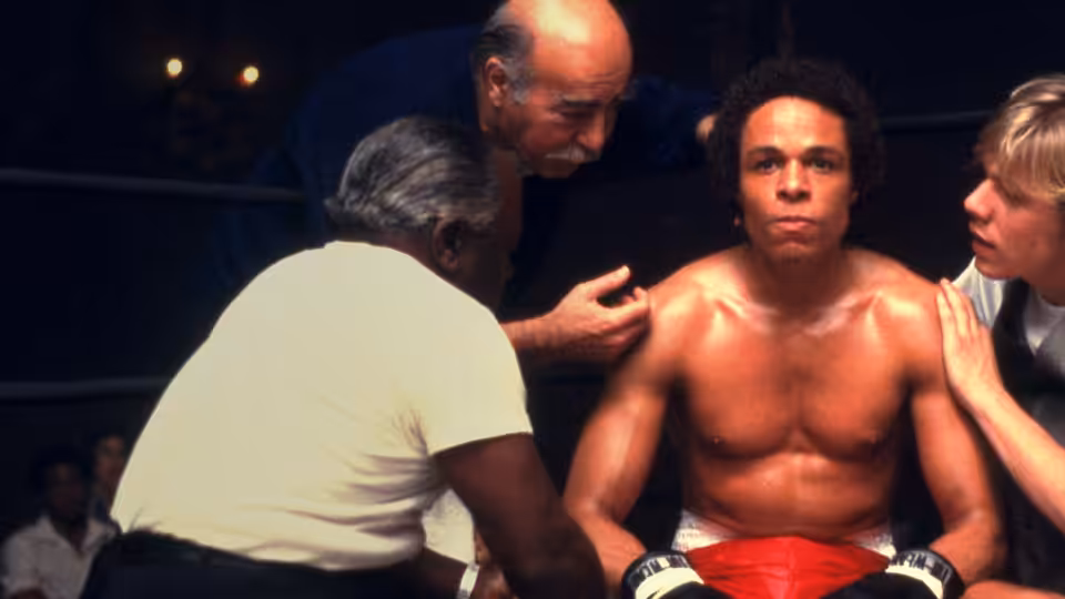 Leon Johnson (Leon Isaac Kennedy) sits in the boxing ring corner as trainers tend to him