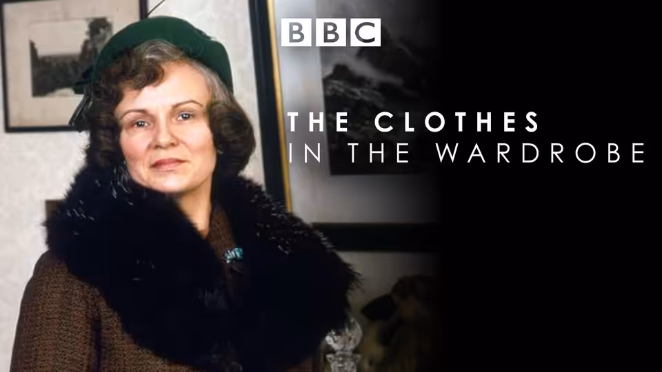 Lili (Jeanne Moreau) stands indoors wearing a green hat and fur-collared coat