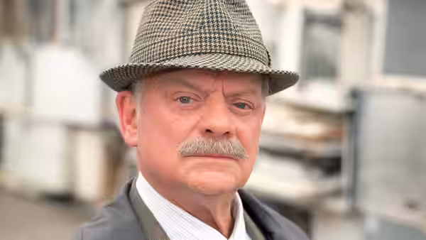 DI Jack Frost (David Jason) in a tweed cap, standing on a town street