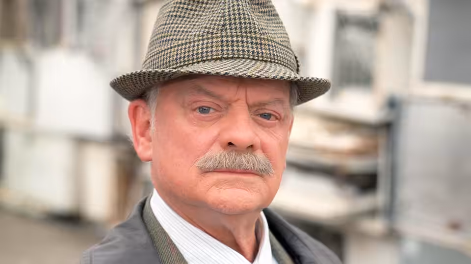 DI Jack Frost (David Jason) in a tweed cap, standing on a town street