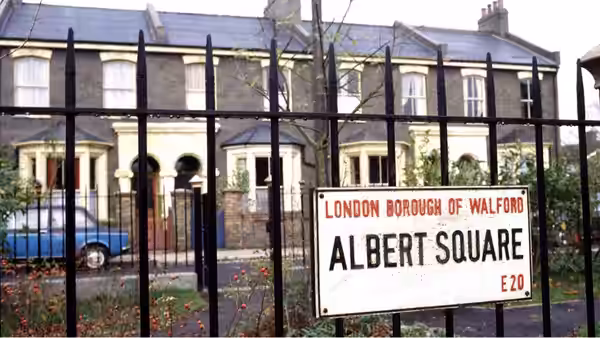 An Albert Square sign stands before a row of houses behind iron railings