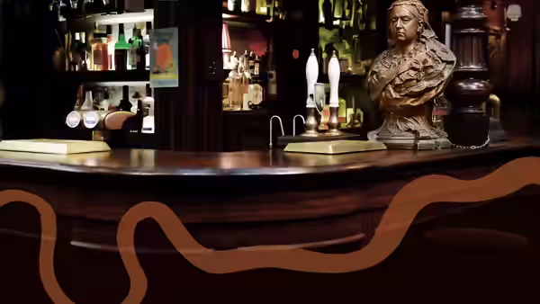 The pub bar sits empty, with beer taps, bottles and a bust
