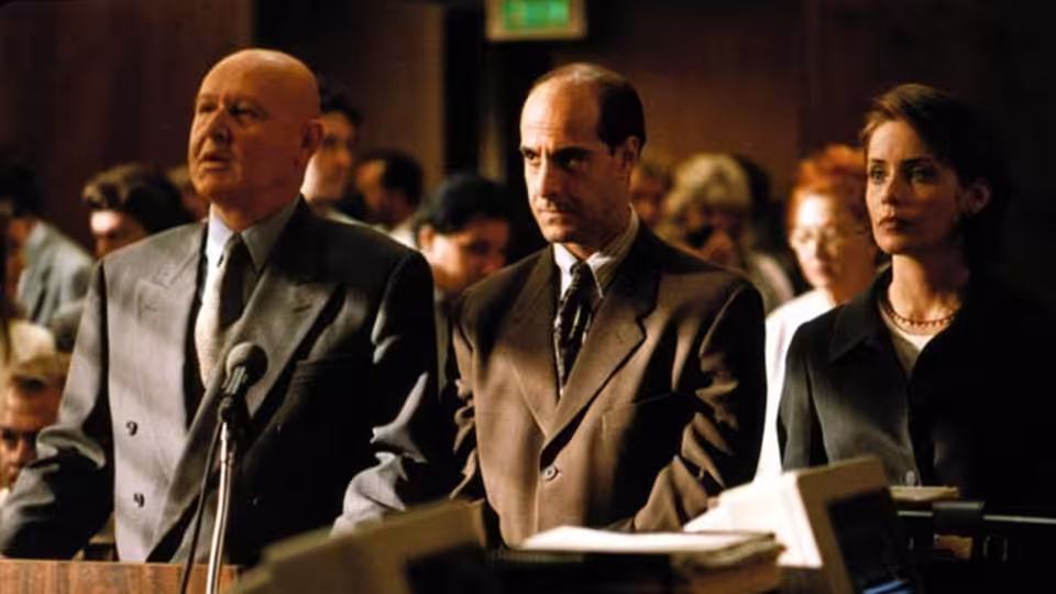 Ted Hoffman (Daniel Benzali) addresses a courtroom, with Richard Cross (Stanley Tucci) and a woman beside him