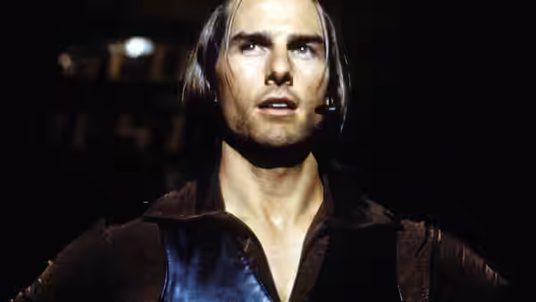 Frank T.J. Mackey (Tom Cruise) speaking onstage wearing a headset microphone