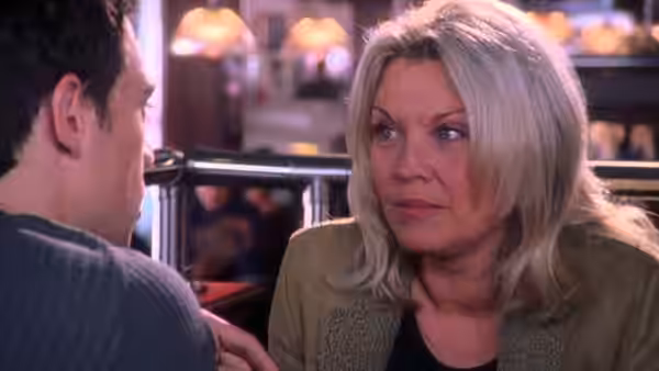 Alison Braithwaite (Amanda Redman) talks with a man across a café table