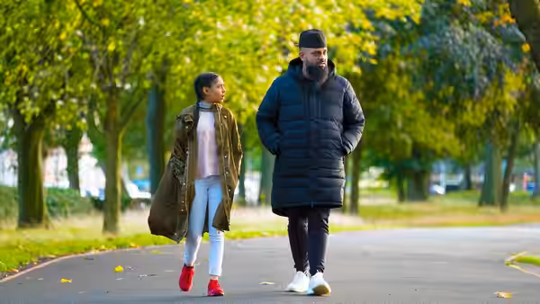 Mobeen (Guz Khan) walks beside Aqsa (Duaa Karim) along a tree-lined park path