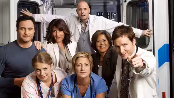 Hospital staff gather in a corridor as a doctor in a white coat points outward