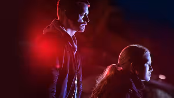 Stephen Holder (Joel Kinnaman) and Sarah Linden (Mireille Enos) watch something in the dark