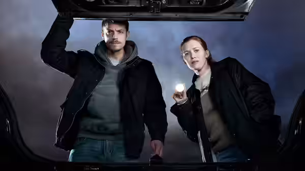 Stephen Holder (Joel Kinnaman) and Sarah Linden (Mireille Enos) peer into an open trunk