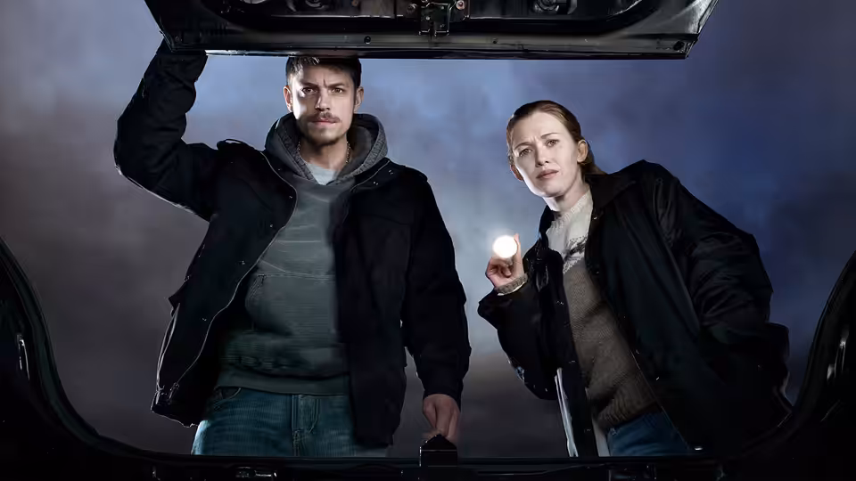 Stephen Holder (Joel Kinnaman) and Sarah Linden (Mireille Enos) peer into an open trunk