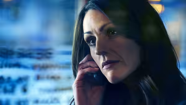 Rachel Bailey (Suranne Jones) listens on her phone beside a wall covered with photographs