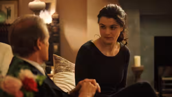 Nancy Pierpan (Rachel Weisz) sits beside Johnny Worricker (Bill Nighy) in a warmly lit room