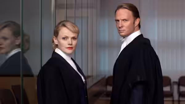 Martha Costello (Maxine Peake) and Clive Reader (Rupert Penry-Jones) stand in a courthouse corridor