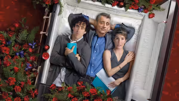 Matt LeBlanc, Sean Lincoln (Stephen Mangan) and Beverly Lincoln (Tamsin Greig) lie together in a flower-lined coffin