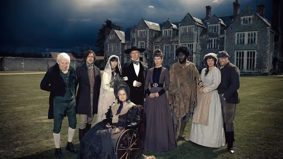 A group of Victorian-dressed residents gathers on the lawn before a country house