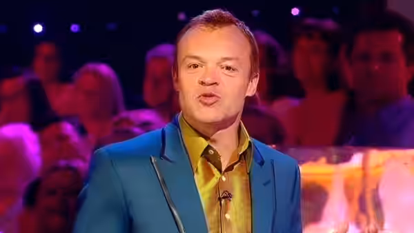 Graham Norton speaks to the audience in the brightly lit studio
