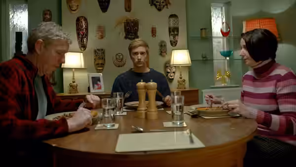 Kieren Walker (Luke Newberry) sits between his parents at the family dining table