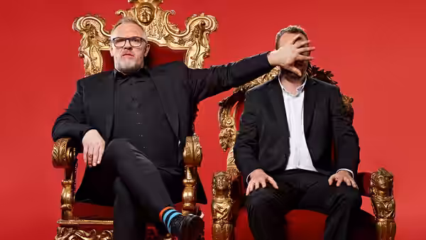 Greg Davies reaches across to cover Alex Horne’s face as they sit on golden thrones