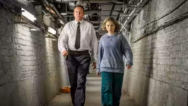 David Murdoch (Philip Glenister) and Lucy Murdoch (Sammy Winward) walk through a narrow underground passage