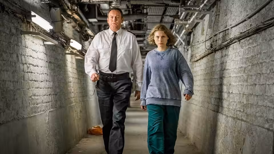 David Murdoch (Philip Glenister) and Lucy Murdoch (Sammy Winward) walk through a narrow underground passage