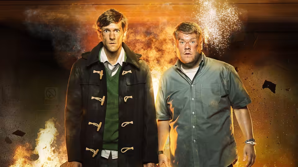Sam Pinkett (Mathew Baynton) and Phil Bourne (James Corden) stand before an explosion