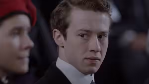 Tibby Schlegel (Alex Lawther) glances sideways beside a person wearing a red beret