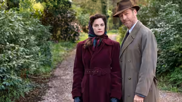 Alison Wilson (Ruth Wilson) and Alec Wilson (Iain Glen) stand together on a garden path