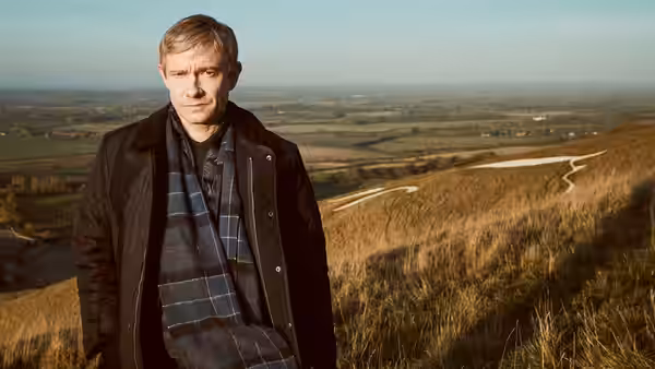 Martin Freeman as Steve Fulcher stands on a hillside above the countryside
