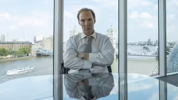 Dominic Cummings (Benedict Cumberbatch) stands with folded arms beside Thames-facing windows