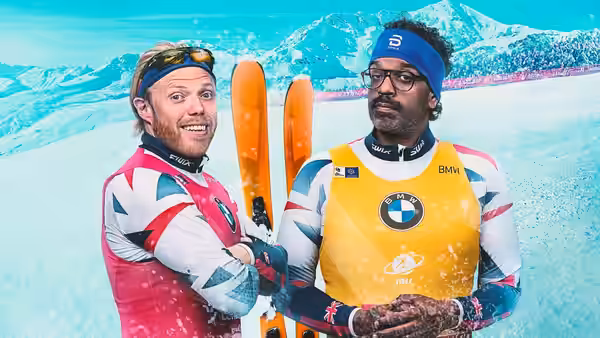 Rob Beckett and Romesh Ranganathan stand in ski gear with skis against a snowy mountain backdrop
