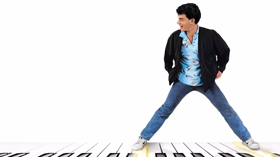 Josh (Tom Hanks) standing with legs apart on a giant piano keyboard